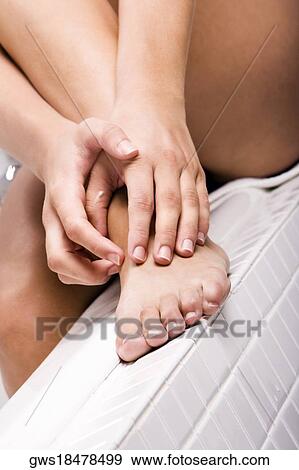 Woman touching her foot View Large Photo Image Stock Photo - Woman touching her foot. Fotosearch