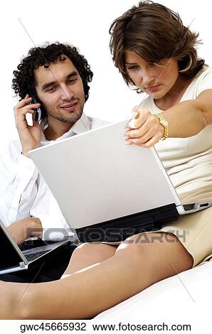 Young couple looking at a laptop View Large Photo Image Stock Image - Young couple looking at a laptop. Fotosearch