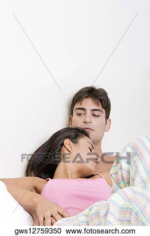 Young couple lying on the bed View Large Photo Image Stock Image - Young couple lying on the bed. Fotosearch