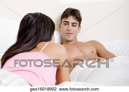Young couple lying on the bed View Large Photo Image Stock Image - Young couple lying on the bed. Fotosearch