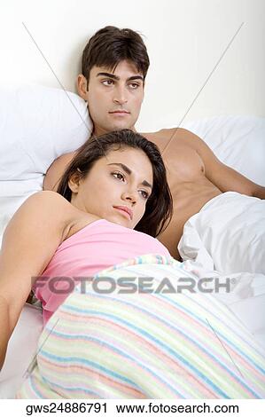 Young couple lying on the bed View Large Photo Image Stock Image - Young couple lying on the bed. Fotosearch
