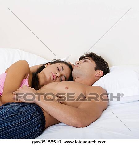 Young couple lying on the bed View Large Photo Image Stock Image - Young couple lying on the bed. Fotosearch
