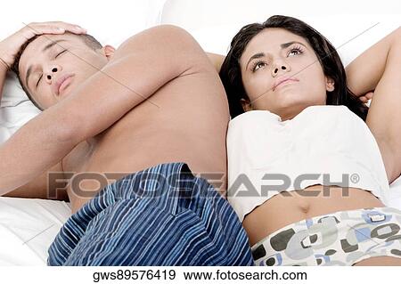 Young couple lying on the bed View Large Photo Image Stock Photo - Young couple lying on the bed. Fotosearch