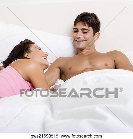 Young couple lying on the bed View Large Photo Image Stock Photography - Young couple lying on the bed. Fotosearch