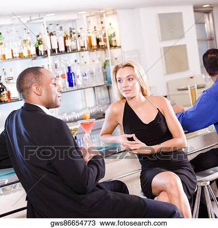 Young couple sitting at a bar counter View Large Photo Image Stock Image - Young couple sitting at a bar counter. Fotosearch