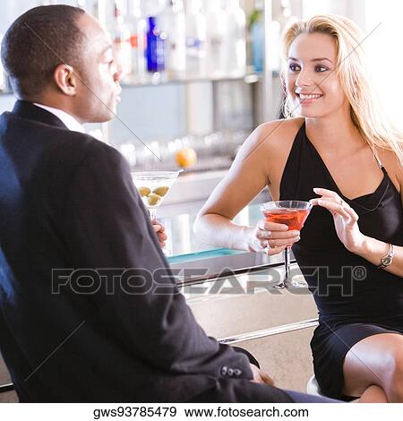 Young couple sitting at a bar counter View Large Photo Image Stock Photo - Young couple sitting at a bar counter. Fotosearch