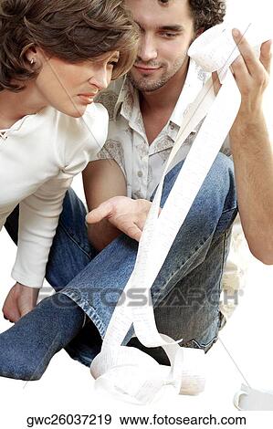 Stock Photo - Young man showing a receipt to a young woman. Fotosearch