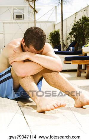 Young man sitting at the poolside View Large Photo Image Picture - Young man sitting at the poolside. Fotosearch