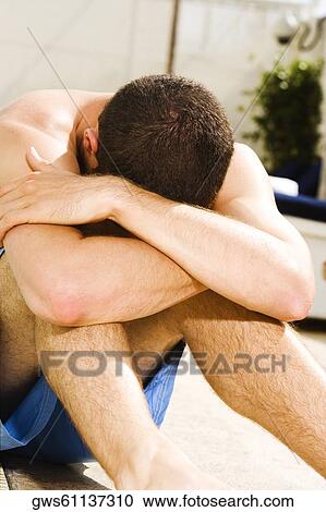 Young man sitting at the poolside View Large Photo Image Stock Image - Young man sitting at the poolside. Fotosearch