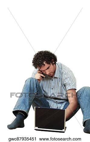 Young man talking on a mobile phone and using a laptop View Large Photo Image Stock Image - Young man talking on a mobile phone and using a laptop. Fotosearch