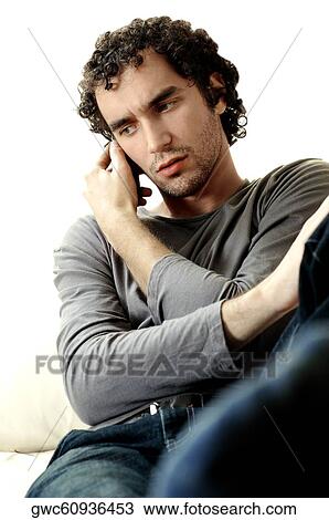 Young man talking on a mobile phone View Large Photo Image Stock Image - Young man talking on a mobile phone. Fotosearch