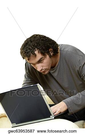 Young man using a laptop View Large Photo Image Stock Photo - Young man using a laptop. Fotosearch
