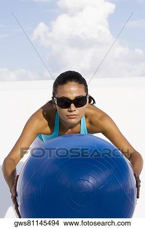 Young woman holding a fitness ball View Large Photo Image Picture - Young woman holding a fitness ball. Fotosearch
