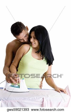 Young woman ironing with a young man embracing her from behind View Large Photo Image Stock Image - Young woman ironing with a young man embracing her from behind. Fotosearch