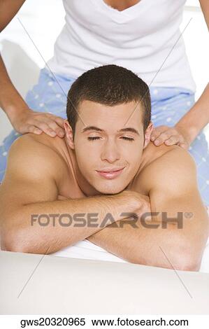 Young woman massaging a young man's shoulders View Large Photo Image Stock Photography - Young woman massaging a young man's shoulders. Fotosearch