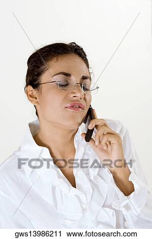 Young woman talking on a mobile phone with her eyes closed View Large Photo Image Stock Image - Young woman talking on a mobile phone with her eyes closed. Fotosearch