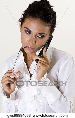 Young woman talking on a mobile phone View Large Photo Image Stock Image - Young woman talking on a mobile phone. Fotosearch