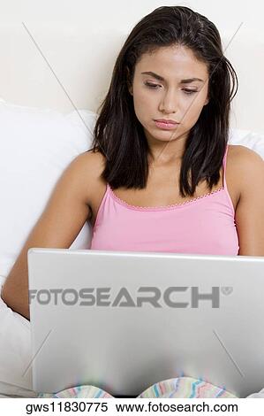 Young woman using a laptop View Large Photo Image Stock Photography - Young woman using a laptop. Fotosearch