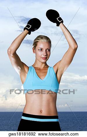 Young woman wearing boxing gloves View Large Photo Image Stock Image - Young woman wearing boxing gloves. Fotosearch