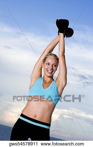 Young woman wearing boxing gloves View Large Photo Image Stock Image - Young woman wearing boxing gloves. Fotosearch