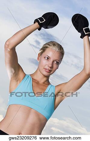 Stock Photograph - Young woman wearing boxing gloves. Fotosearch