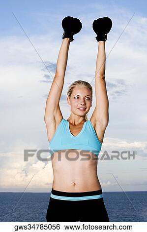 Young woman wearing boxing gloves View Large Photo Image Stock Photograph - Young woman wearing boxing gloves. Fotosearch