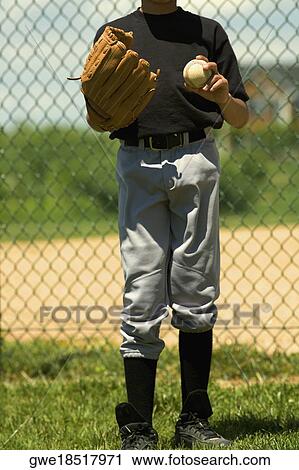 Baseball player holding a baseball in a baseball field View Large Photo Image Stock Image - Baseball player holding a baseball in a baseball field. Fotosearch