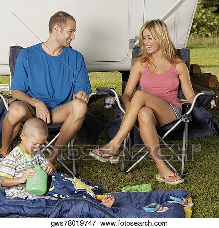 Boy sitting on a quilt with his parents looking cheerful View Large Photo Image Stock Photo - Boy sitting on a quilt with his parents looking cheerful. Fotosearch