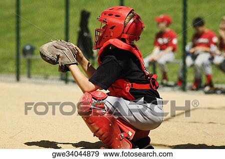 Close-up of a baseball catcher crouching on a baseball field View Large Photo Image Stock Photo - Close-up of a baseball catcher crouching on a baseball field. Fotosearch