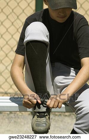 Close-up of a baseball player tying his shoelaces View Large Photo Image Stock Photo - Close-up of a baseball player tying his shoelaces. Fotosearch