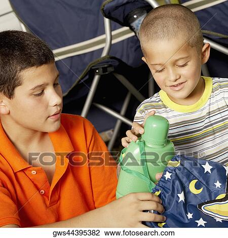 Close-up of a boy and his brother holding a water bottle View Large Photo Image Stock Image - Close-up of a boy and his brother holding a water bottle. Fotosearch