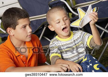 Close-up of a boy looking at his brother holding a star View Large Photo Image Stock Photo - Close-up of a boy looking at his brother holding a star. Fotosearch