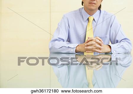 Close-up of a businessman sitting in an office View Large Photo Image Stock Image - Close-up of a businessman sitting in an office. Fotosearch