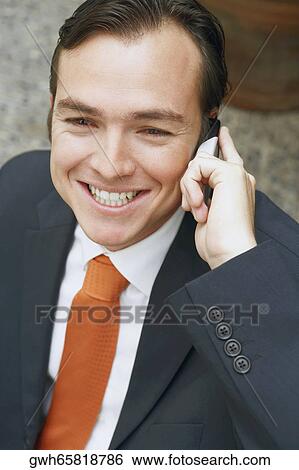 Close-up of a businessman talking on a mobile phone View Large Photo Image Stock Photograph - Close-up of a businessman talking on a mobile phone. Fotosearch