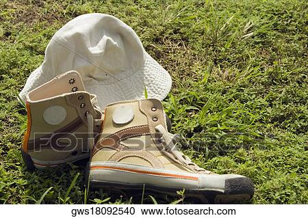 Stock Image - Close-up of a cap with a pair of shoes. Fotosearch