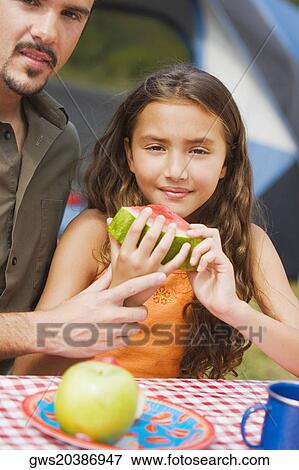 Close-up of a father and his daughter holding a slice of watermelon View Large Photo Image Stock Photo - Close-up of a father and his daughter holding a slice of watermelon. Fotosearch