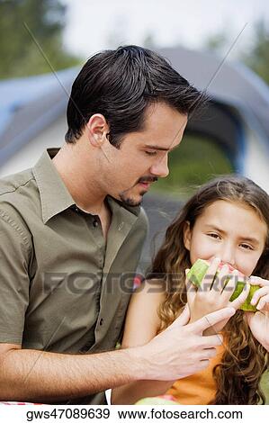 Close-up of a father and his daughter eating a slice of watermelon View Large Photo Image Stock Photo - Close-up of a father and his daughter eating a slice of watermelon. Fotosearch