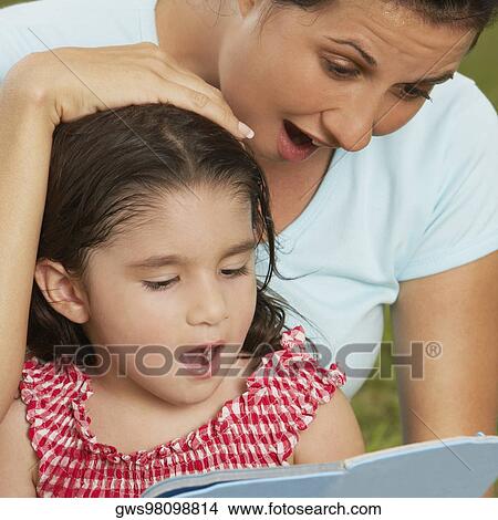Close-up of a girl and her mother reading a book View Large Photo Image Picture - Close-up of a girl and her mother reading a book. Fotosearch