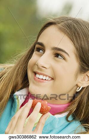 Close-up of a girl holding a strawberry View Large Photo Image Stock Image - Close-up of a girl holding a strawberry. Fotosearch