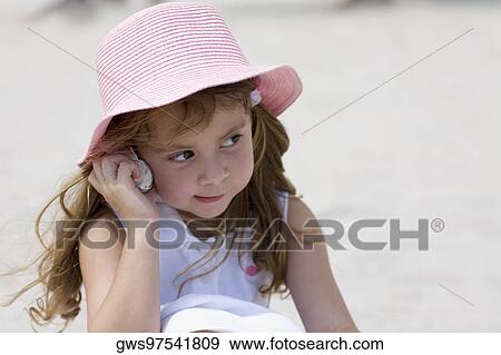 Close-up of a girl listening to a conch shell View Large Photo Image Stock Photo - Close-up of a girl listening to a conch shell. Fotosearch