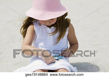 Close-up of a girl playing with a starfish on the beach View Large Photo Image Picture - Close-up of a girl playing with a starfish on the beach. Fotosearch