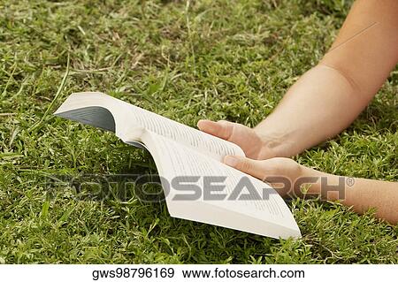 Stock Photo - Close-up of a human hand holding a book. Fotosearch