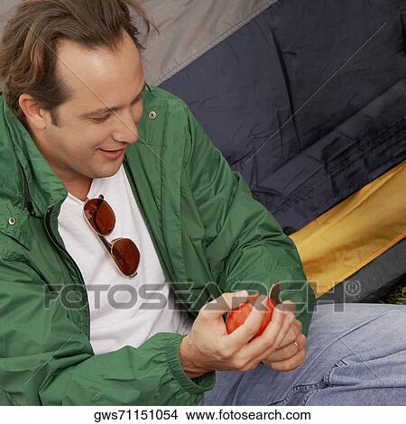 Close-up of a mature man cutting an apple View Large Photo Image Picture - Close-up of a mature man cutting an apple. Fotosearch