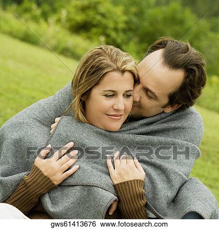 Stock Photograph - Close-up of a mature man embracing a mid adult woman. Fotosearch