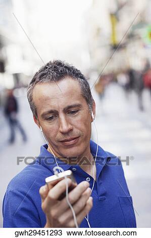 Close-up of a mature man listening to an MP3 Player View Large Photo Image Stock Image - Close-up of a mature man listening to an MP3 Player . Fotosearch