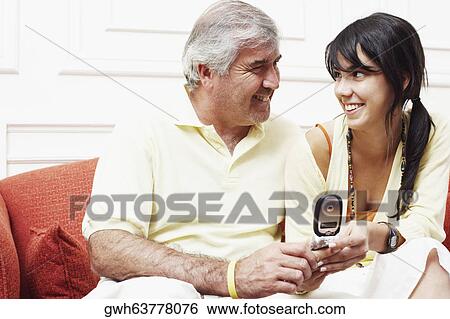 Close-up of a mature man sitting with his daughter on a couch and looking at each other View Large Photo Image Stock Photograph - Close-up of a mature man sitting with his daughter on a couch and looking at each other. Fotosearch