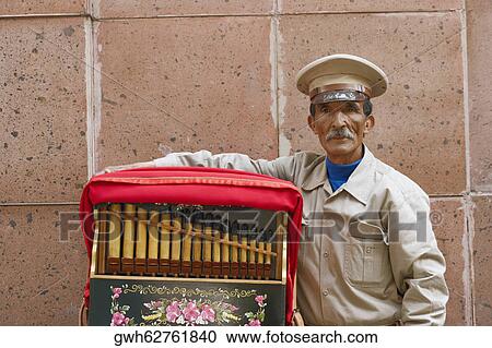 Stock Image - Close-up of a mature man standing with an accordion. Fotosearch