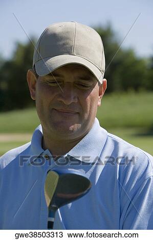 Close-up of a mature man with a golf club on a golf course View Large Photo Image Stock Image - Close-up of a mature man with a golf club on a golf course. Fotosearch