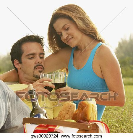 Picture - Close-up of a mid adult couple toasting with wineglasses. Fotosearch