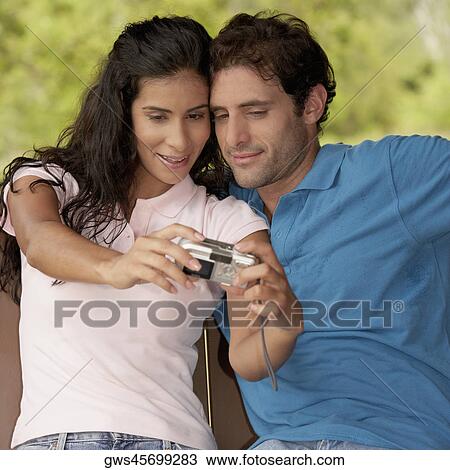 Close-up of a mid adult man and a young woman photographing themselves View Large Photo Image Stock Image - Close-up of a mid adult man and a young woman photographing themselves. Fotosearch